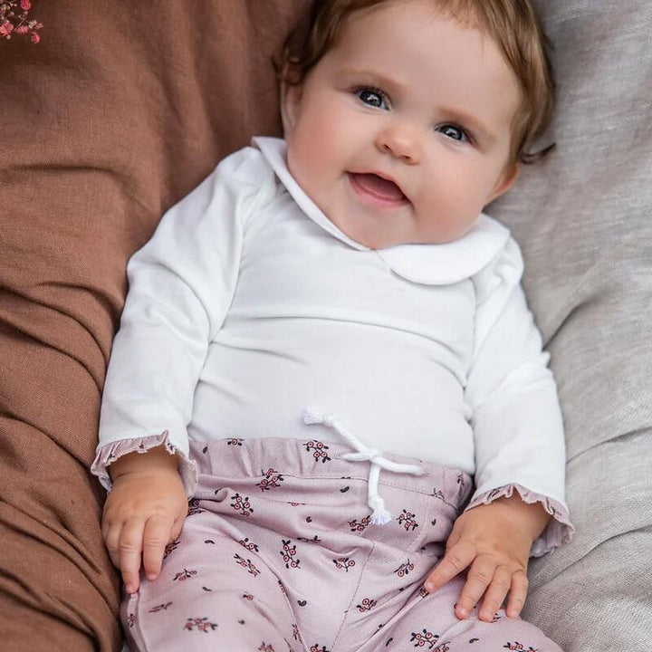 baby in flowery onesie with flowery pants